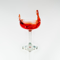 Wine glass with splash out red liquid