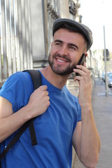 Gorgeous man calling by phone outdoors