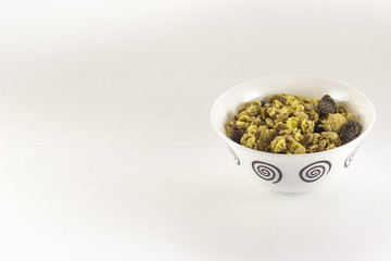 Bowl of muesli with dry fruits on white background