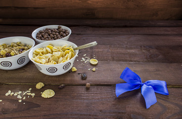Bowls with different cereals breakfast and spoon on wooden table