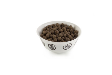 Cereal chocolate balls in bowl on white background