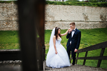 Stylish groom and bride at wooden tribune at their wedding day.