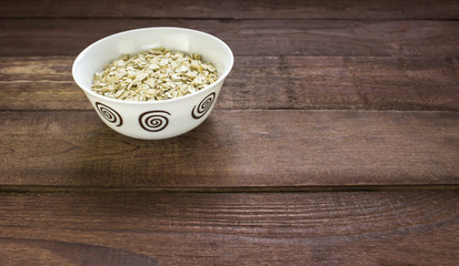 Oatmeal in a white bowl on a  wooden table