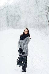 Portrait of a brunette wearing glasses and a gray coat