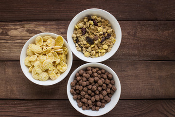 Three bowls of cereals on wooden table