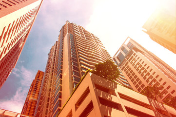Skyscrapers at center of city with bright vivid sun glare effect and burned color effect as hot...