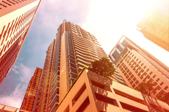 Skyscrapers at center of city with bright vivid sun glare effect and burned color effect as hot weather concept