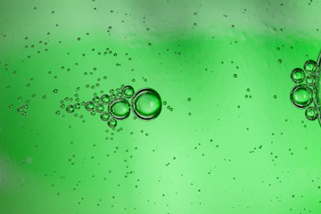 Abstract background from bubbles of carbonated water through a green glass bottle, art image, macro