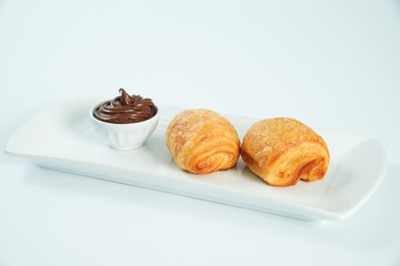 two fresh and tasty croissant over white background