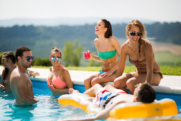 Group of young people enjoying summer at pool