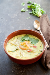 Spicy soup with coconut milk, noodles and shrimps. Eastern cuisine 