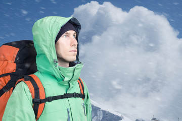 Fototapeta na wymiar Man alpinist looks up against a winter mountain landscape.