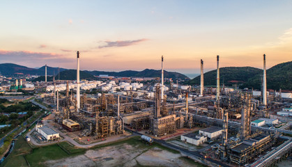 Naklejka premium Aerial view Oil refinery with a background of mountains and sky.The factory is located in the middle of nature and no emissions. The area around the air pure.