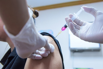 Close-up hands,nurses are vaccinations to patients using the syringe.Doctor vaccinating women in hospital.Are treated by the use of sterile injectable upper arm. injection