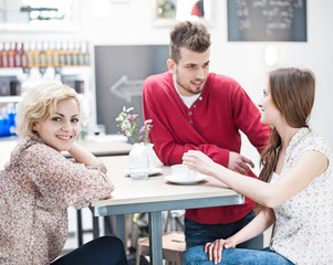 Obraz premium Portrait of smiling woman with friend at cafe table