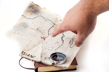 Man point by finger into old damage fake map of island with red cross and treasure chest of pirate