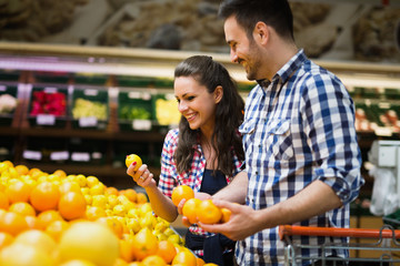 Cheerful couple shopping for organic fruit