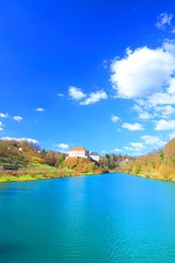 Fototapeta na wymiar River Kupa and Castle on hill, Ozalj in Croatia, blue sky with clouds in background