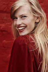 Fototapeta premium Stunning blond smiling in red dress, close up
