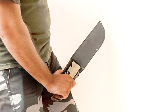 Person in military clothes holds big hunter knife