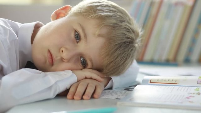 Tired student elementary school does lessons. 