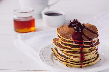 Pancakes with cherry jam on white dish