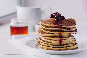 Pancakes with cherry jam on white dish
