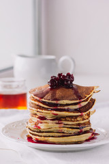 Pancakes with cherry jam on white dish