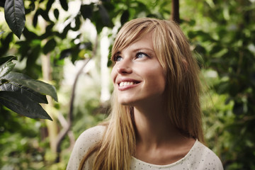 Naklejka premium Beautiful woman smiling amongst plants