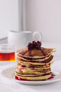 Pancakes with cherry jam on white dish