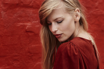 Fototapeta premium Gorgeous blond woman in red dress, looking down