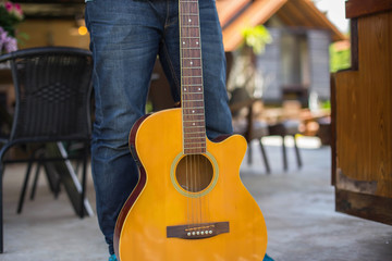 Close up of young hipster man practiced guitar in the park,happy and enjoy playing guitar