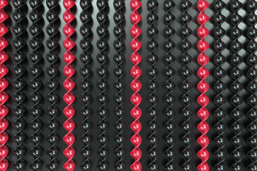 Black and red plastic spiral sticks on black background