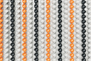 Black, white and orange plastic spiral sticks on white background