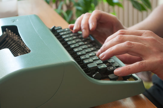 détail mains d'homme sur clavier de machine à écrire ancienne