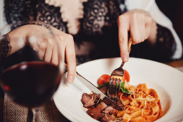 The girl eats apples with Italian pasta with tomato, meat. Close-up
