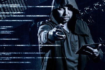 Internet crime concept. Dangerous hacker, in hoodie shirt and dark digital background around, stealing your data.