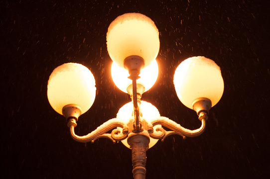 Old street lamp with snow at night