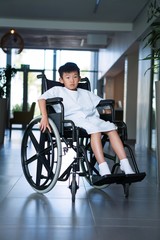 Fototapeta na wymiar Disabled boy patient on wheelchair in hospital corridor