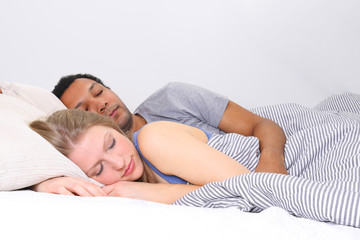 Couple sleeping cuddling in bed