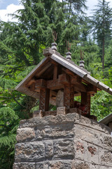 MANALI, INDIA. A small Shiva Temple decorated with wood-carved a swastika and iron tridents.  Naggar, district of Kullu in Himachal Pradesh, India.