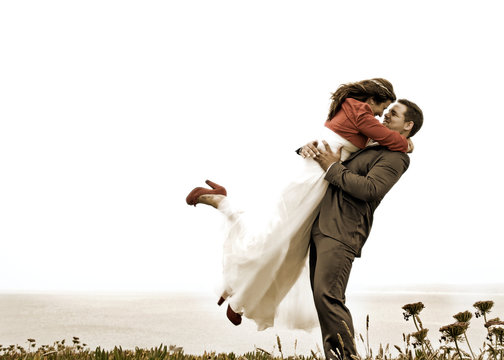 Groom embrassing the bride on the air