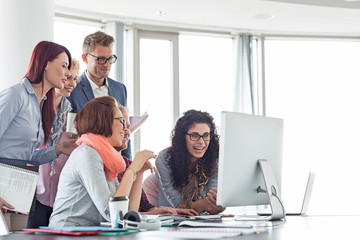 Obraz premium Smiling businesspeople working together at conference table