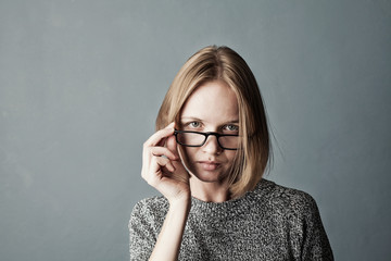 Closeup portrait of woman looking from under glasses
