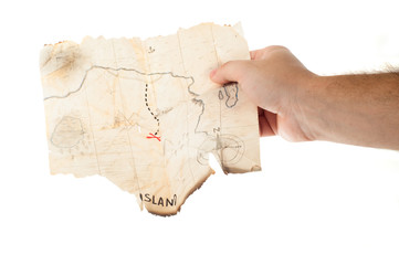 Man holds old vintage fake map of pirates with red cross of treasure chest