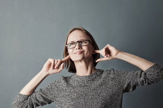 Woman plugging ears with fingers doesn't want to listen