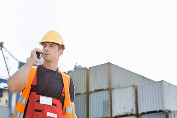 Fototapeta na wymiar Male worker using walkie-talkie in shipping yard