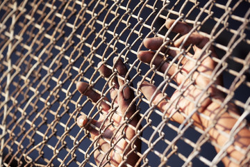 hand of prisoner in jail as background.