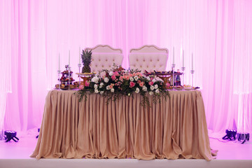 Newlyweds' initials hang on the wall illuminated with violet light