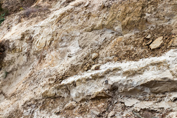 Rocks and sand on a cliff background.